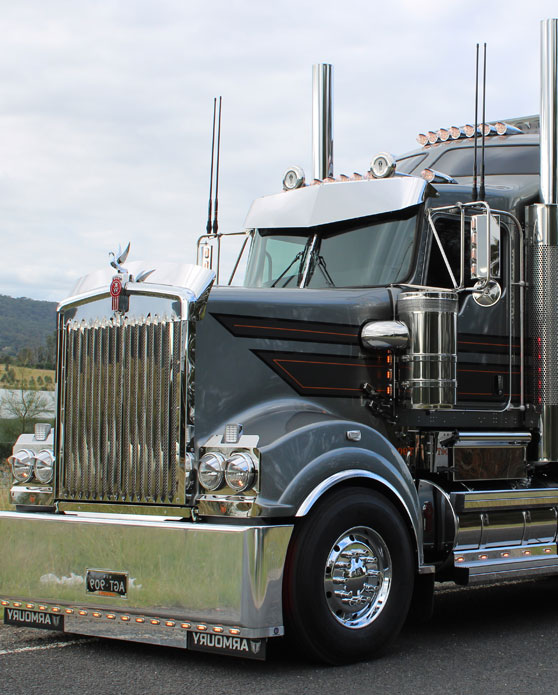 Kenworth truck fitted with Armoury chrome wheels and stainless accessories, showcasing polished finish and custom detailing, parked on Australian highway.